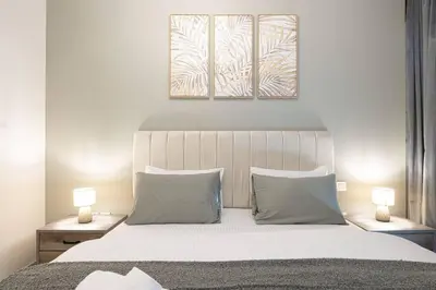 a bedroom with a large white bed with two lamps at Downtown - Burj Khalifa Facing - 2 Bed Luxe Apartment in Dubai