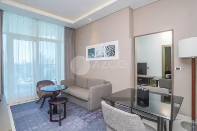 a living room with a couch and a table at Stunning 1 BR Damac Maison Prive in Dubai