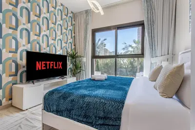 a bedroom with a bed with a tv and a window at Holiday Studio In JVC 0107, Dubai in Dubai