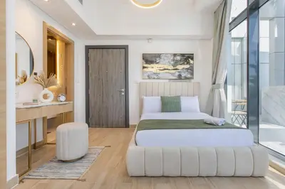 a bedroom with a white bed and a chair at Holiday Studio In JVC 2302, Dubai in Dubai