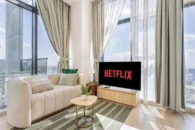 a living room with a white couch and a tv at Holiday Studio In JVC 2302, Dubai in Dubai