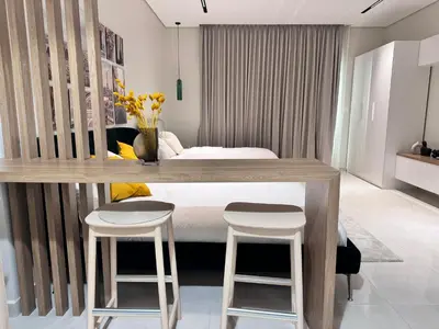 a bedroom with a bed and two stools at Cozy Spacious AG Tower Business Bay, Dubai in Dubai