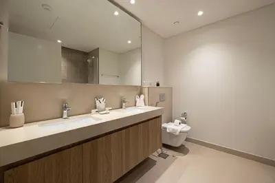 a bathroom with two sinks and a mirror and a toilet at Burj Khalifa View, 2 Balcony w Lounge, Dubai Mall Access, Gym, Infinity-Pool, Playground, BBQ, Family Friendly in Dubai