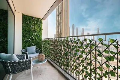 a balcony with two chairs and a plant at Burj Khalifa View, 2 Balcony w Lounge, Dubai Mall Access, Gym, Infinity-Pool, Playground, BBQ, Family Friendly in Dubai
