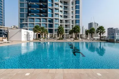 a large swimming pool with buildings in the background at The Smart Concierge - Damac Maison Prive in Dubai