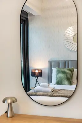 a bedroom with a bed with a round mirror at Amazing 2BR Burj Kalifa View in Dubai