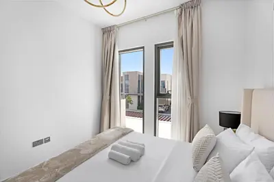 a bedroom with a white bed and a large window at Luxurious 6-Sleeper Villa with Large Outdoor Patio in Dubai