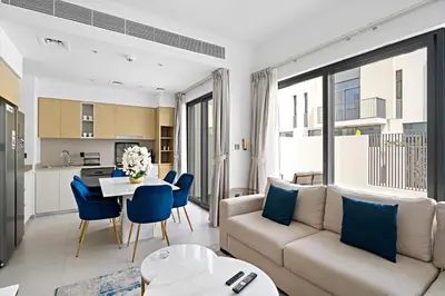 a living room with a couch and a table with blue chairs at Luxurious 6-Sleeper Villa with Large Outdoor Patio in Dubai