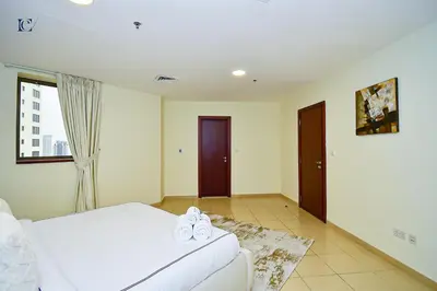 a bedroom with a white bed and a window at Luxury Escapes - Amazing Sea View - 4 Bedrooms Apt with Maids room in JBR in Dubai