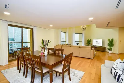 a living room with a table and chairs and a couch at Luxury Escapes - Amazing Sea View - 4 Bedrooms Apt with Maids room in JBR in Dubai
