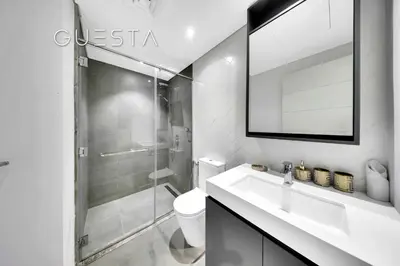 a white bathroom with a sink and a shower at Belgravia Square, Jumeirah Village Circle in Dubai