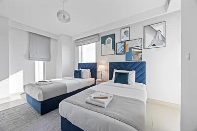two beds in a room with blue and white at 5242 Tower 2 - Chic Two Bedroom in Dubai