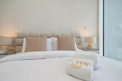 a bedroom with a large white bed with pillows at Upgraded Banyan Tree 2 Bed in JLT in Dubai