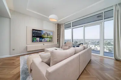 a living room with a couch and large windows at Upgraded Banyan Tree 2 Bed in JLT in Dubai