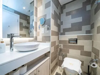 a bathroom with a sink and a toilet at Seven Palm Studio with Rooftop Infinity Pool in Dubai