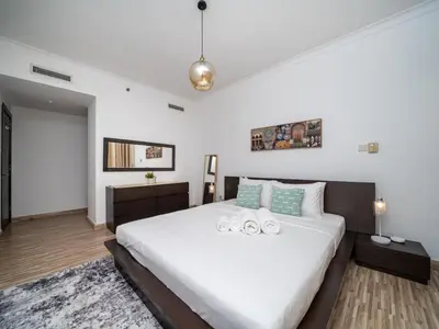 a bedroom with a large white bed in a room at 2 Bedroom Delight in The Greens Dubai in Dubai