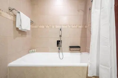 a bath tub in a bathroom with a shower at GuestReady - Groove Getaway in Downtown Dubai in Dubai