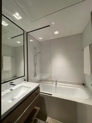 a bathroom with a tub and a sink and a mirror at Palace Dubai Creek Harbour Residences Skyline Apartment in Dubai