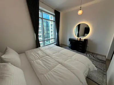 a bedroom with a large white bed and a mirror at Best Downtown Apartment in Dubai in Dubai