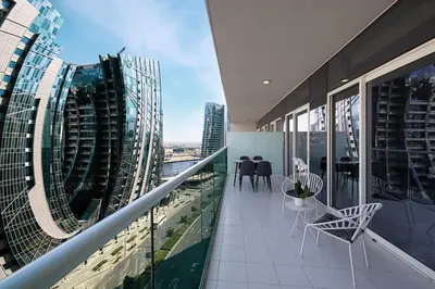 a balcony with chairs and tables on a building at Modern Two Bedroom Apartment with Private Balcony By HSHOME - Downtown Dubai in Dubai