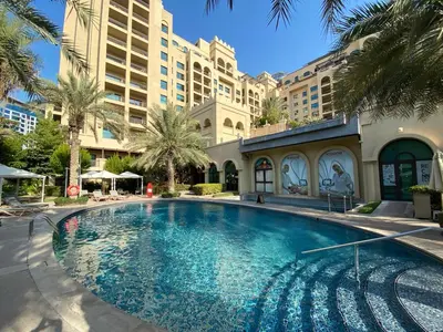 a large swimming pool in front of a building at Fairmont North 2BR Balcony Sea View in Dubai