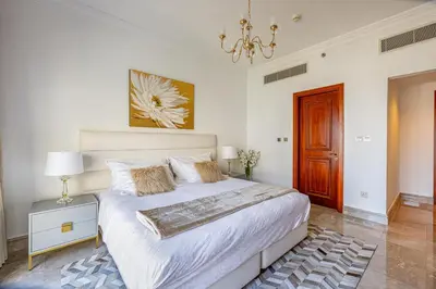 a bedroom with a large bed and a chandelier at Fairmont North 2BR Balcony Sea View in Dubai