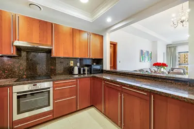 a kitchen with wooden cabinets and a stove at Fairmont North 2BR Balcony Sea View in Dubai
