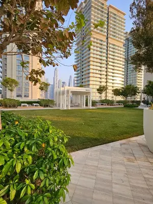 a park with tall buildings in the background at Experience Bliss 1BR Haven with Stunning Sea Views - 50AB1 in Dubai