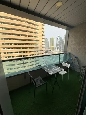 a balcony with a table and chairs and a large window at Studio Apartment near JBR in Dubai