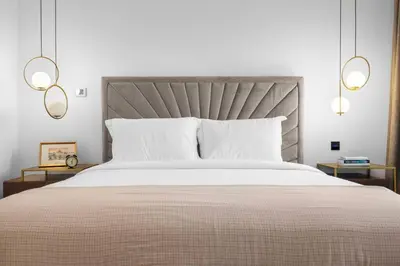a bedroom with a large white bed with two lamps at Burj Khalifa & Downtown Views - 3BR Family Retreat Near Dubai Mall in Dubai
