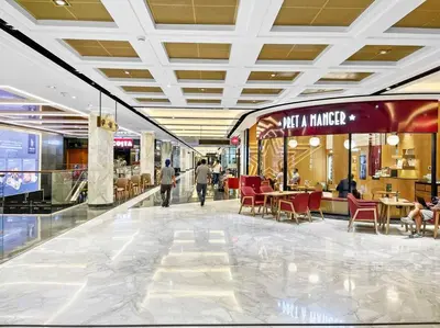 a mall with tables and chairs and people walking through it at Burj Khalifa & Downtown Views - 3BR Family Retreat Near Dubai Mall in Dubai