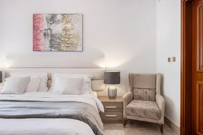 a bedroom with a bed and a chair at Fairmont North 2BR 2 Balconies Sea View in Dubai