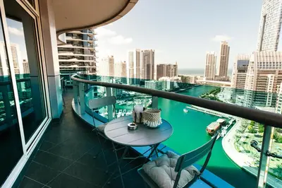 a balcony with a table and chairs and a view of the city at Stunning 2BR with Captivating Marina View - 17AB06 in Dubai
