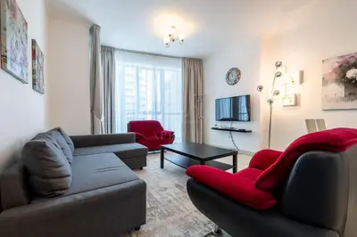 a living room with a couch and red chairs at 1BD apartment in Torch Tower, Dubai Marina in Dubai