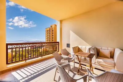 a living room with a couch and chairs on a balcony at Fairmont North 2BR Full Sea View in Dubai