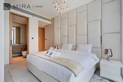 a bedroom with a large white bed and a bathroom at Mira Holiday Homes - Lovely 2 BDR with Sea View in Dubai