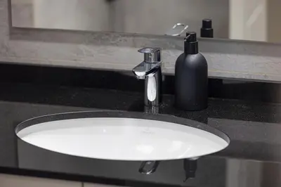 a bathroom sink with a soap bottle next to it at Arabian-Inspired 1BR - Polo Residence Near Burj in Dubai