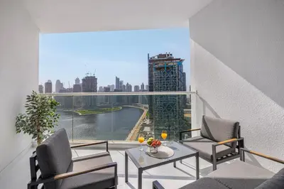 a balcony with a table and chairs and a view of a city at Livin' Holidays - Luxury studio with Bay view in Dubai