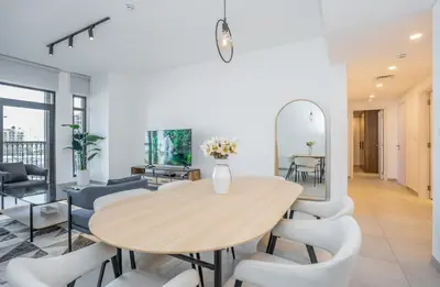 a dining room with a wooden table and chairs at Vacay Lettings 2 Bed Retreat near Burj Al Arab in Dubai
