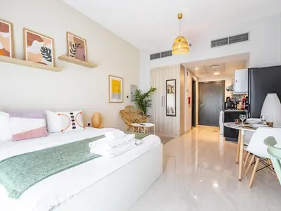 a white bedroom with a large bed and a dining room at Charming Studio Escape With Unobstructed City View in Dubai
