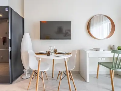 a dining room with a white table and chairs at Charming Studio Escape With Unobstructed City View in Dubai