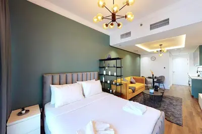 a bedroom with a large bed and a living room at Shiny & Fresh - Studio with Lake View - JLT in Dubai