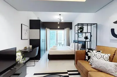 a living room with a couch and a bedroom at Earthy & Sharp - Studio with Lake View - JLT in Dubai