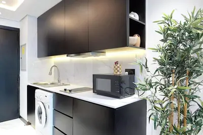 a kitchen with a sink and a microwave at Earthy & Sharp - Studio with Lake View - JLT in Dubai