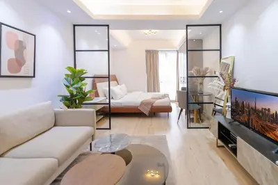 a living room with a couch and a tv at Airy and Peaceful - Studio - JLT in Dubai