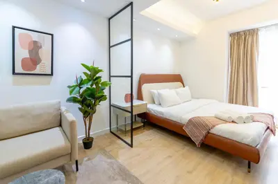 a bedroom with a bed and a couch and a chair at Airy and Peaceful - Studio - JLT in Dubai