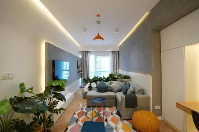 a living room with a couch and some plants at Bright and cozy - Studio - JLT in Dubai