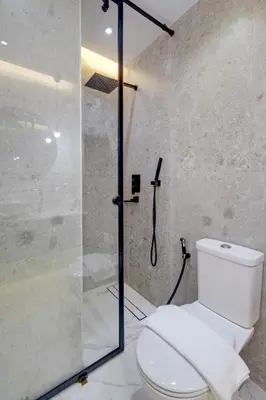 a bathroom with a toilet and a glass shower at Bright and cozy - Studio - JLT in Dubai