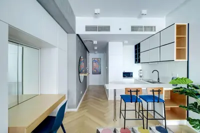 a kitchen with a wooden table and blue chairs at Bright and cozy - Studio - JLT in Dubai