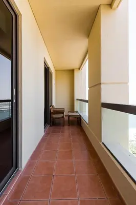 a corridor of a building with a chair and a window at JBR Full Sea View Apartment 1 BR in Dubai